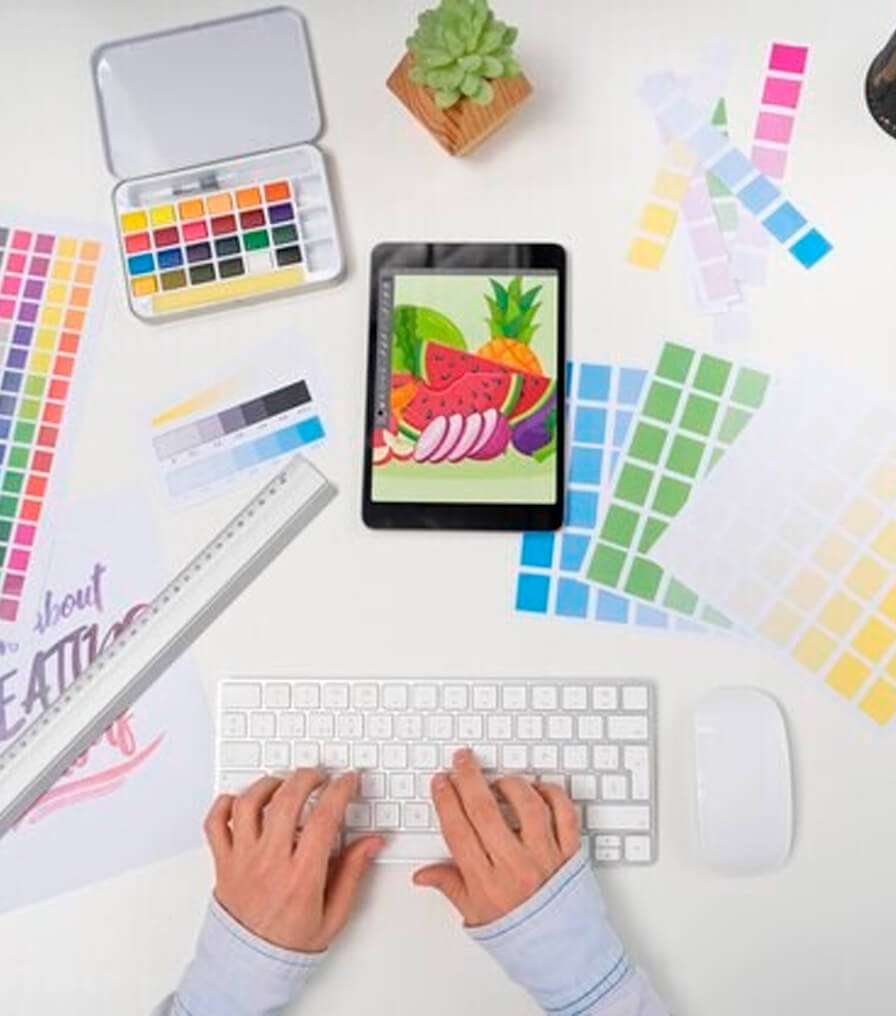 A designer uses a tablet and keyboard to create, representing 911MYWEB Graphic Design Solutions.
